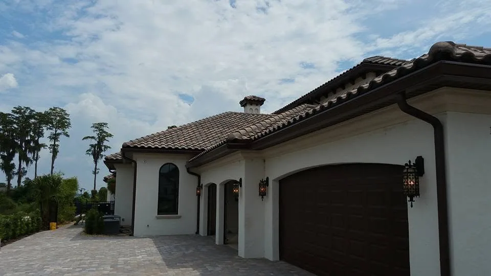 Brown garage doors stucco home barrel tile bronze gutter downspout, Lake Mary